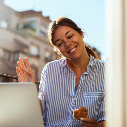 cheerful-young-woman-staying-connected-via-laptop