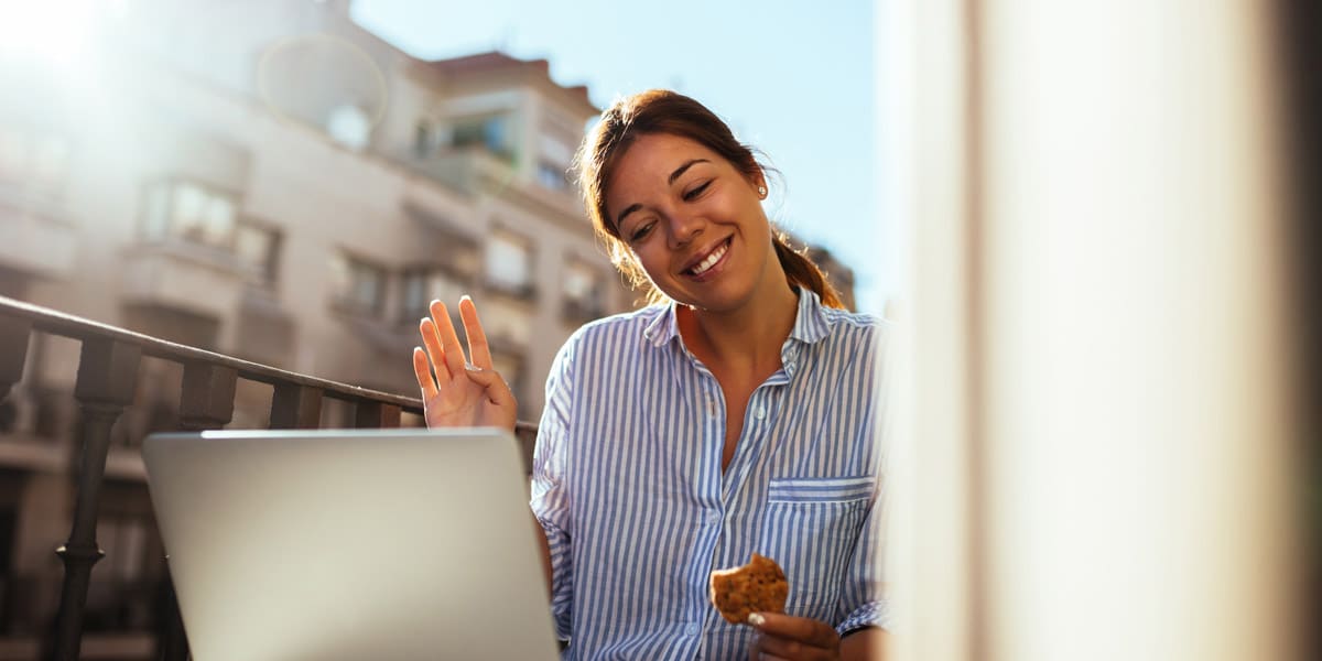 cheerful-young-woman-staying-connected-via-laptop