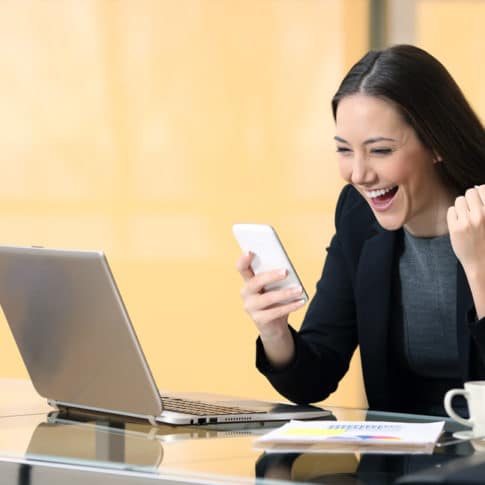 excited businesswoman after closing a virtual sales call on her cell phone