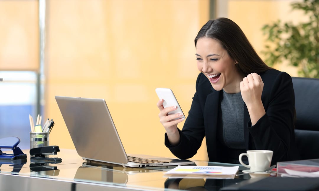 excited businesswoman after closing a virtual sales call on her cell phone